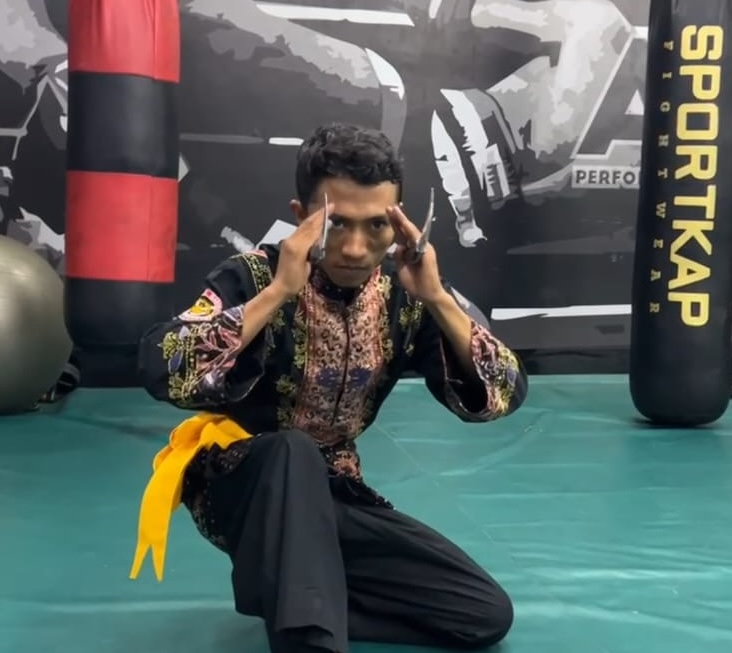 Pesilat Silek Harimau Minangkabau Indonesia memperagakan gerakan tradisional yang sarat filosofi keberanian dan kebijaksanaan.